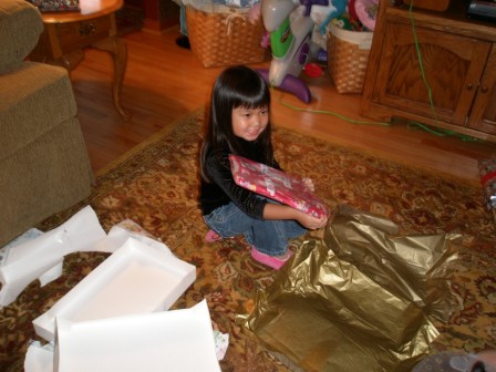 Kasen opening a couple of presents on Christmas Eve